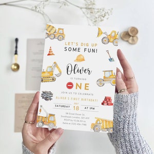 Peut inclure: Invitation à un premier anniversaire sur le thème de la construction avec des véhicules de chantier jaunes et orange, un casque de chantier et le texte "Let's Dig Up Some Fun!"  Oliver a un an. Rejoignez-nous pour célébrer le premier anniversaire d'Oliver ! Samedi 18 juillet à 13h. 58 Great Dover St. Southwark London, SE1 4YF. RSVP avant le 10.06.XX à Katie au (123) 456-7788.