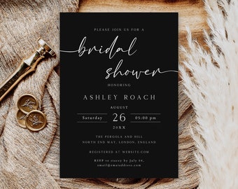 May include: A black invitation card with white script that reads "bridal shower" and details for Ashley Roach's shower. The card is on a textured beige surface with a gold wax seal and a gold pen.