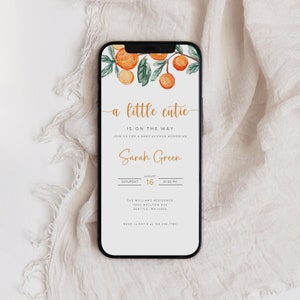 Puede incluir: Una invitaci&oacute;n digital para un baby shower con una ilustraci&oacute;n de acuarela de flores de naranja. El texto dice "a little cutie is on the way" e incluye el nombre "Sarah Green", la fecha, la hora y los detalles de la ubicaci&oacute;n.