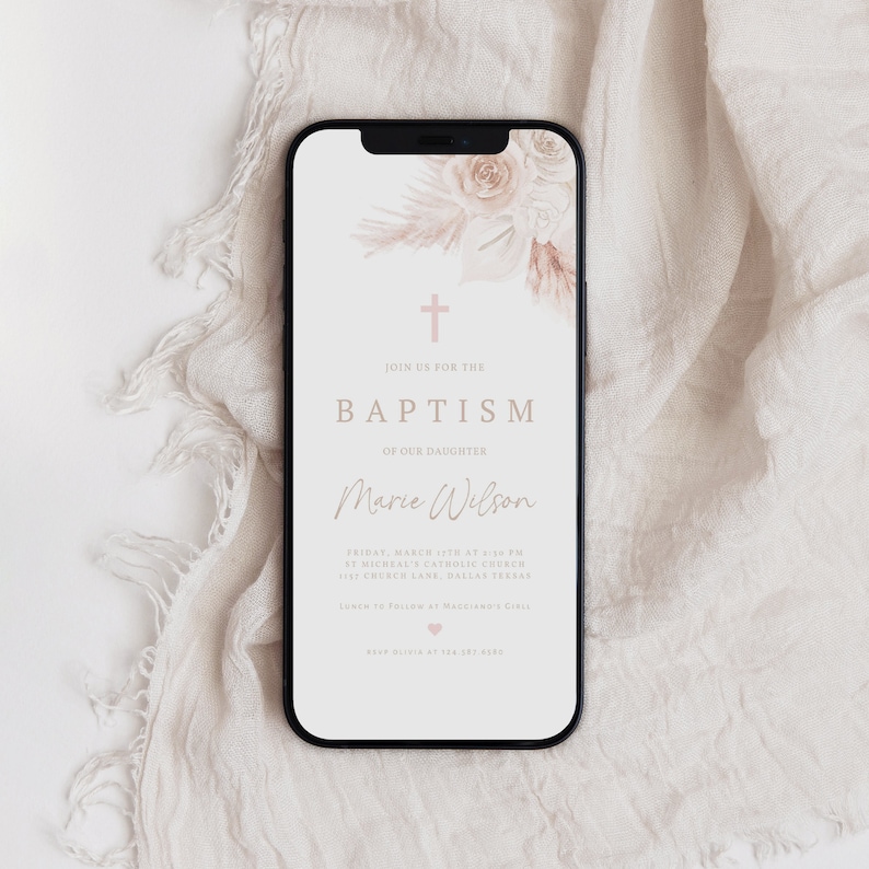 May include: A smartphone displays a baptism invitation with floral accents. The invitation features the text "JOIN US FOR THE BAPTISM OF OUR DAUGHTER Marie Wilson" in a soft, neutral color palette. A cross and floral elements are at the top.