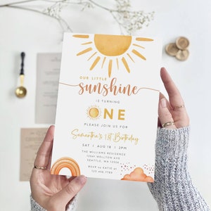 Puede incluir: Una tarjeta de invitación blanca con un sol amarillo y el texto "Our little sunshine is turning one. Please join us for Samantha's 1st Birthday. Sat I Aug 18 I 2PM. The Williams Residence 12541 Wellton Ave Seattle, WA 12556. RSVP to Katie at 123.456.7780."