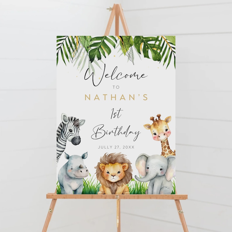 Op de afbeelding: Welkom bij Nathans 1e verjaardagsschild met een jungle thema. Het bord toont een zebra, een giraffe, een neushoorn, een leeuw en een olifant met groene bladeren en gouden glitter. De datum is 27 juli 20XX.