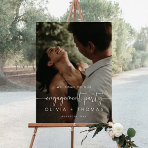 Può includere: Un cartello di benvenuto per una festa di fidanzamento con una foto di una coppia in un ambiente boschivo. Il cartello recita "Benvenuti alla nostra festa di fidanzamento Olivia + Thomas 16 agosto 20XX".