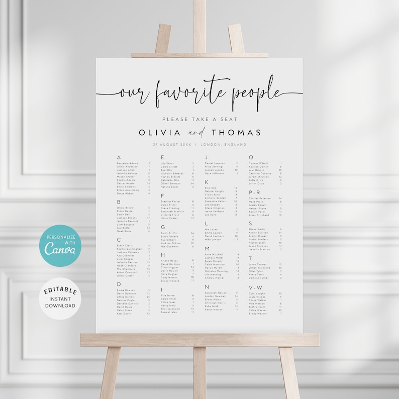 May include: A white wedding seating chart with the text "our favourite people" at the top. The chart lists guests alphabetically by last name with their table numbers. The chart is on a wooden easel.