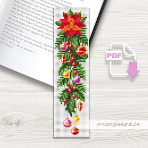 Può includere: Un segnalibro natalizio a punto croce con una stella di Natale, ornamenti e bacche. Il design è prevalentemente verde, rosso e oro, con uno sfondo bianco. Il testo "Amazing DesignsBySA" è visibile.