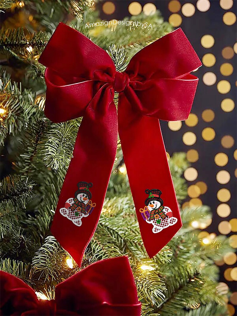 May include: A large, festive red velvet bow with long, flowing tails, adorned with embroidered snowman appliques. The bow is displayed on a Christmas tree, creating a holiday decoration.