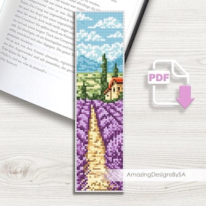 May include: A handmade bookmark with a pixelated design. The top section depicts a blue sky with white clouds and green trees. The middle shows a house with a red roof. The bottom section shows a field of purple lavender with a path. The text "AmazingDesignsBySA" is visible.