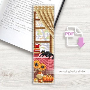 May include: A cross-stitch bookmark with an autumnal theme. It shows a window with curtains, a black cat, books, a mug, sunflowers, and a pumpkin. The bookmark includes a PDF icon and the text "AmazingDesignsBySA".