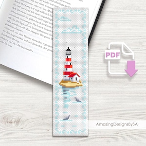 Könnte beinhalten: Kreuzstich-Lesezeichen mit einem Leuchtturm mit rot-weißen Streifen, einem roten Dach und einer schwarzen Spitze. Das Lesezeichen hat einen hellblauen Rand mit Wolken und Vögeln. Der Text "AmazingDesignsBySA" befindet sich in der unteren rechten Ecke.