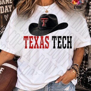 Könnte beinhalten: Ein weißes Kurzarm-T-Shirt mit einer Grafik eines schwarzen Cowboyhuts, der vorne mit einem roten Texas Tech-Logo versehen ist. Unter dem Hut ist der Schriftzug TEXAS TECH in großen, abgenutzten roten und schwarzen Großbuchstaben aufgedruckt.