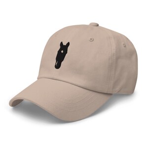 May include: A beige baseball cap with a black horse head silhouette embroidered on the front.