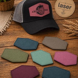 Könnte beinhalten: Eine schwarze Trucker-Cap mit Netzrücken und einem rosafarbenen Lederaufnäher mit dem Text CHASING HIGH und einer Pferdegrafik. Unter der Kappe befinden sich sieben sechseckige Aufnäher in verschiedenen Farben, darunter Petrol, Oliv, Salbei, Grau und Magenta.