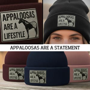 Può includere: Una collezione di berretti in vari colori, tra cui nero, bordeaux, blu navy e rosa. Ogni berretto presenta una toppa rettangolare con la scritta "APPALOOSAS ARE A LIFESTYLE" e una grafica di un cavallo. È presente anche la frase "APPALOOSAS ARE A STATEMENT".