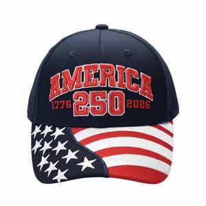 May include: A navy blue baseball cap with the word "AMERICA" embroidered in red, along with "250" and the years "1776" and "2026". The brim features a design of the American flag.