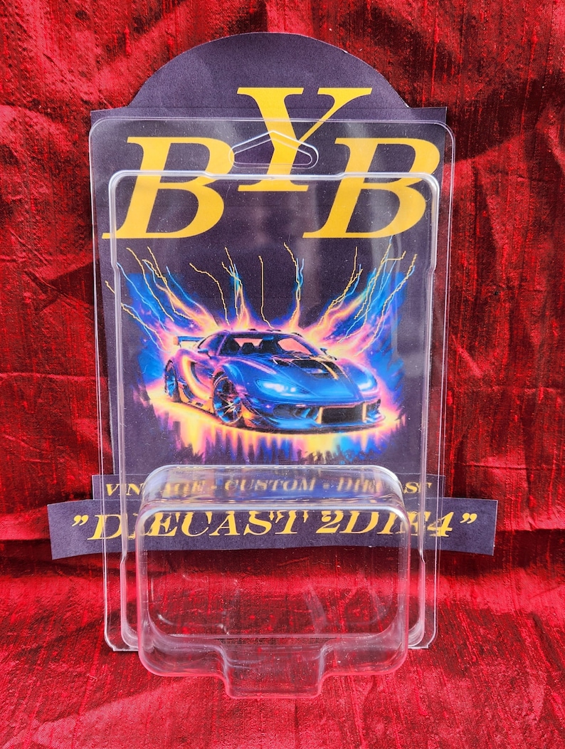 May include: A clear plastic display case with a blue sports car graphic. The graphic has a lightning bolt design and the text "BYB" in gold. The bottom of the case has the text "DIECAST 2DNA".