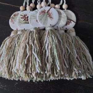 Handgemaakt ornament van dennenappelklei • Neutraal winterdecor met kwastje