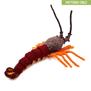 Puede incluir: Un juguete de langosta de crochet con un cuerpo rojo y marrón y patas naranjas.