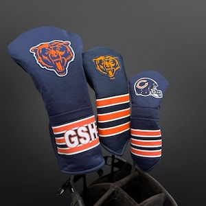 Puede incluir: Tres fundas para palos de golf de color azul marino con detalles en naranja y blanco. Cada funda presenta un logotipo de los Chicago Bears. La funda más grande tiene las letras "GSH" en blanco. Las fundas están en una bolsa de golf.