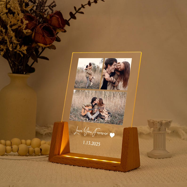 May include: A lighted acrylic photo display with three images of a couple. The display has a wooden base and the words "Love You Forever" and the date 1.13.2025 are etched on the front. The display is lit with a warm glow.