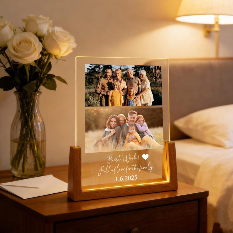 May include: A wooden-based illuminated photo display featuring two family photographs. The clear acrylic front displays the text "Best Wish! Full of love for the family 1.6.2025". The display is lit from within, creating a warm glow.