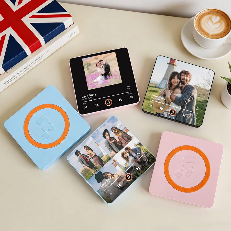 May include: A selection of square music players and coasters. The players show photos and music controls, in pink and black. Two coasters are light blue and pink, each with an orange music note design.