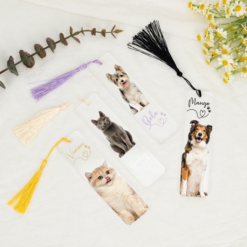 May include: Four white bookmarks with colorful tassels. Each bookmark features a different pet photo and name: Vivian, Bela, Mango, and Buddy. The bookmarks are perfect for dog and cat lovers.