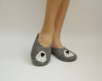 May include: Gray felt slippers with a white and black cat face design.