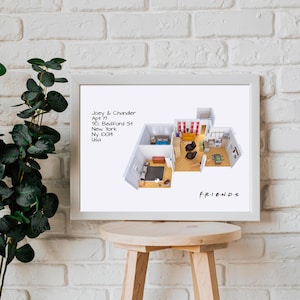 May include: A white framed print with a floor plan of the apartment from the TV show Friends. The text on the print reads "Joey & Chandler, Apt 19, 90 Bedford St, New York, NY 10014, USA" and "FRIENDS".
