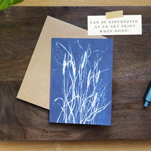 Puede incluir: Una tarjeta de felicitaci&oacute;n azul con un dise&ntilde;o bot&aacute;nico blanco, acompa&ntilde;ada de un sobre de papel kraft. La tarjeta presenta el texto "CAN BE REPURPOSED AS AN ART PRINT WHEN DONE!"