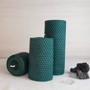 Puede incluir: Tres velas de panal de abeja verdes de diferentes tamaños. Las velas están hechas de cera de abeja y tienen un aspecto natural y rústico.