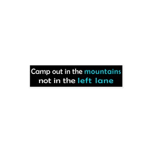 Puede incluir: Pegatina en blanco y negro con el texto "Camp out in the mountains not in the left lane" en blanco con "mountains" en azul.