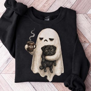 Könnte beinhalten: Ein schwarzes Sweatshirt mit Rundhalsausschnitt und einer Grafik eines weißen Geistes, der eine braune Tasse mit der Aufschrift MEH hält und einen schwarzen Mops trägt. Der Geist hat einen traurigen Gesichtsausdruck, während der Mops nach vorne blickt.