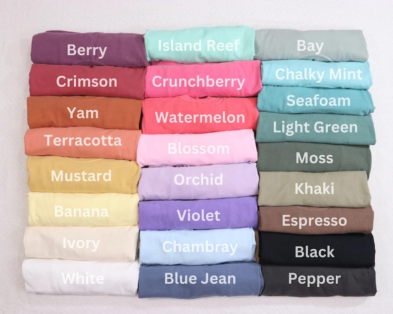 May include: A color chart of 24 fabric swatches, each folded in half and labeled with a color name. The colors include Berry, Crimson, Yam, Terracotta, Mustard, Banana, Ivory, White, Island Reef, Crunchberry, Watermelon, Blossom, Orchid, Violet, Chambray, Blue Jean, Bay, Chalky Mint, Seafoam, Light Green, Moss, Khaki, Espresso, Black, and Pepper.