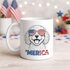 May include: White ceramic mug with a black and white dog illustration wearing sunglasses with an American flag design. The word "'MERICA" is printed below the dog in red, white, and blue.