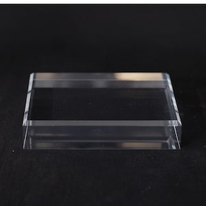 Peut inclure: Une boîte d'exposition rectangulaire en acrylique transparent avec un couvercle. La boîte est transparente, permettant une visibilité totale du contenu. Le design est simple et moderne, adapté pour présenter de petits objets.