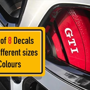 以下が含まれることがあります： 「Set of 8 Decals, 4 Different sizes, 38 Colours」と黒い文字で書かれた黄色の看板。画像には、白い文字で「GTI」と書かれた赤い車の部品も表示されています。その部品は、銀色の車のパネルの隣にあります。