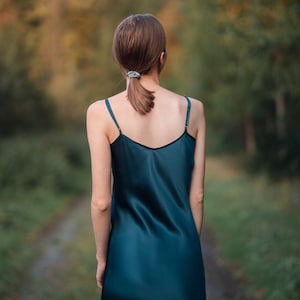 Beautiful woman wearing  navy blue silk slip bias cut dress or nightie outdoors