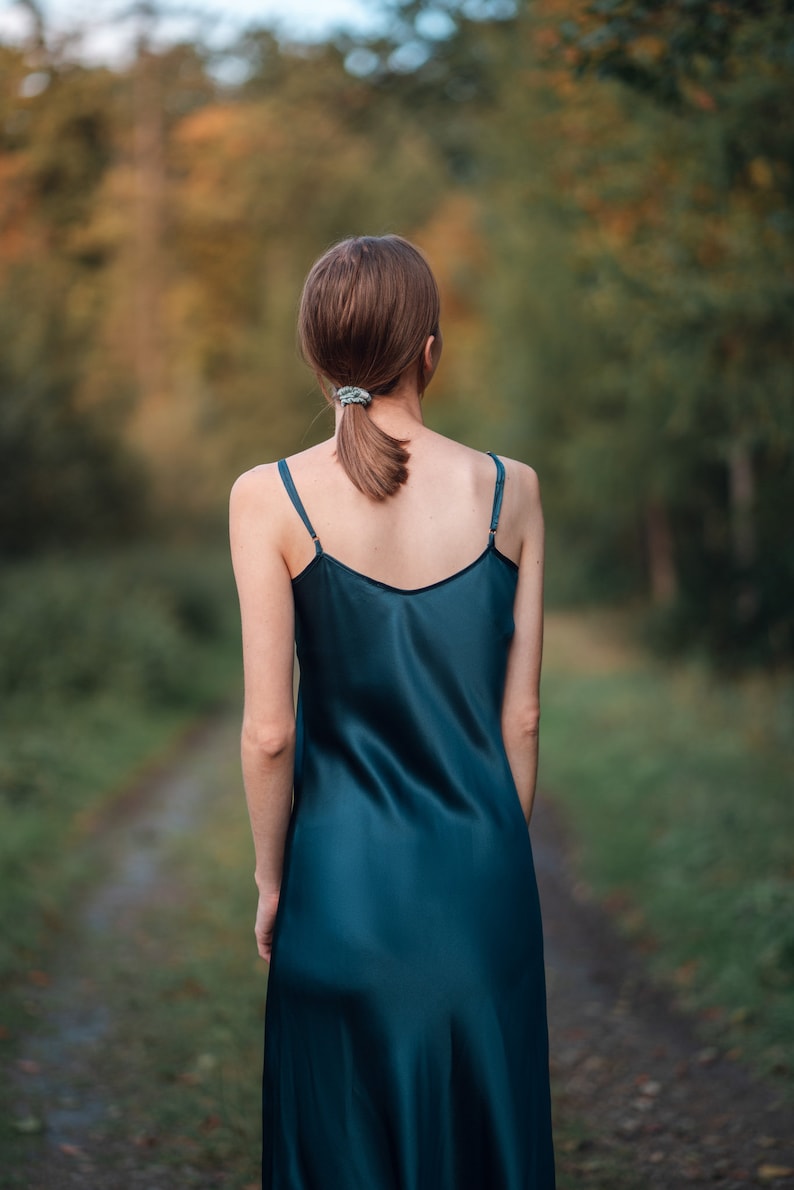 Beautiful woman wearing  navy blue silk slip bias cut dress or nightie outdoors