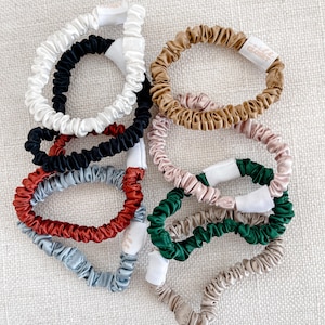 May include: A set of ten colorful silk scrunchies. The scrunchies are made of soft, stretchy silk and are perfect for keeping hair out of your face. They come in a variety of colors, including black, white, red, green, blue, and brown.