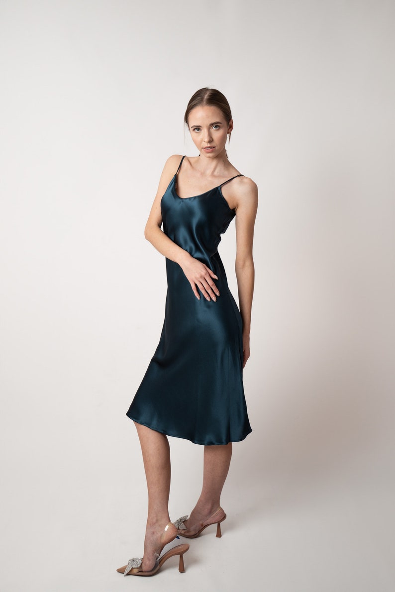 Beautiful woman wearing  navy blue silk slip bias cut dress or nightie in studio