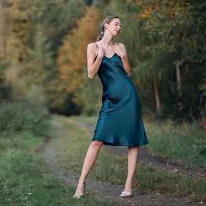 Beautiful woman wearing  navy blue silk slip bias cut dress or nightie outdoors