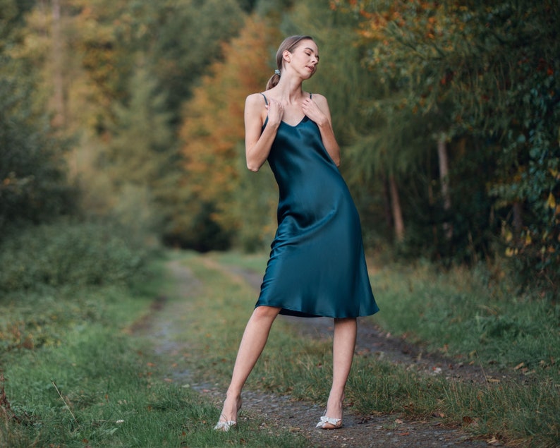 Beautiful woman wearing  navy blue silk slip bias cut dress or nightie outdoors