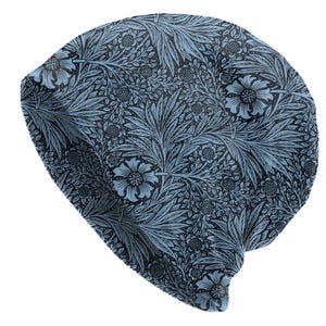 May include: A blue beanie hat with a floral pattern. The hat features a repeating design of stylized flowers and leaves in shades of blue against a dark background. The beanie is made of a soft, flexible material.