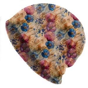 May include: A beanie hat with a floral pattern. The hat features a repeating design of pink and blue flowers, with hints of yellow and green, set against a beige background. The beanie is made of a soft, lightweight material.