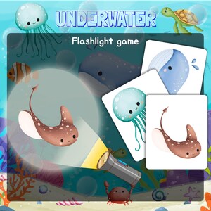 May include: An underwater-themed game with a flashlight. The game includes cards with images of a whale, a jellyfish, a stingray, and a turtle. The cards are laid out on a blue background with a flashlight shining on them.