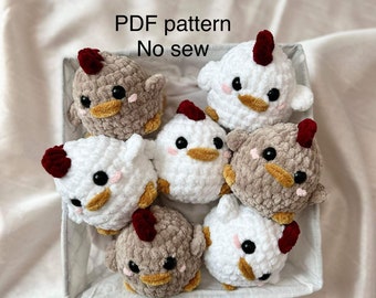May include: A collection of handmade crochet chicken toys in a gray basket. The chickens are white and brown with red crests, yellow beaks, and black eyes. The text "PDF pattern No sew" is visible.