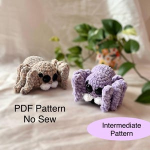 Op de afbeelding: Twee gehaakte spinnen, één bruin en één paars, met grote zwarte ogen en witte tanden. De bruine spin staat links en de paarse spin rechts. Tekst op de afbeelding luidt "PDF Pattern No Sew" en "Intermediate Pattern".