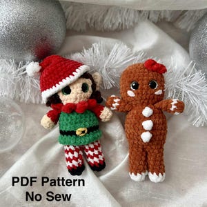 May include: Two crocheted Christmas ornaments: an elf and a gingerbread person. The elf wears a red hat, green tunic, and red and white striped pants. The gingerbread person has a red bow and white accents. The text "PDF Pattern No Sew" is at the bottom.