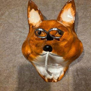 May include: A set of three ceramic mugs with a speckled, matte finish. Each mug features a different color: light blue, cream, and gray. The mugs have a simple, modern design with a rounded shape and a comfortable handle.