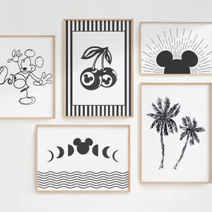 Op de afbeelding: Vijf ingelijste kunstafdrukken met zwart-wit illustraties. De prints tonen een Mickey Mouse-lijntekening, kersen, een Mickey Mouse-hoofd met zonnestralen, palmbomen en een Mickey Mouse-hoofd met maanfasen en golven.
